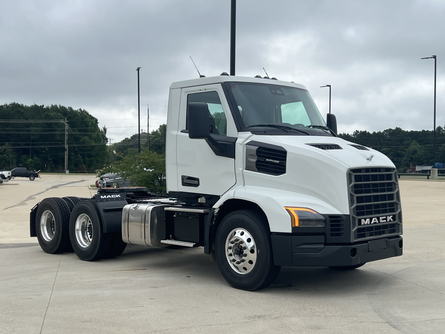 Mack AN64T conventional daycab truck side view showing cab, twin rear axles, chrome fuel tanks, and Mack emblem on grille.