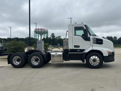 Mack AN64T conventional daycab tractor in white, side view showing cab and rear tandem wheels, fuel tanks, and exhaust stack.