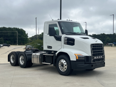 Mack AN64T conventional daycab truck side view showing cab, twin rear axles, chrome fuel tanks, and Mack emblem on grille.