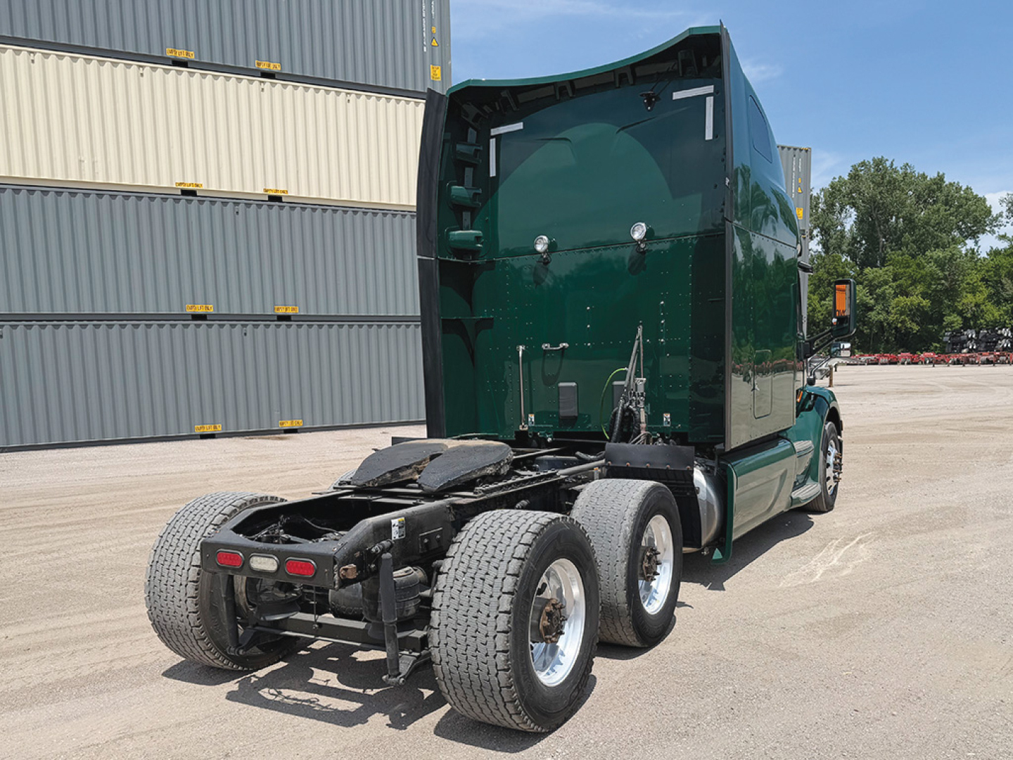 Peterbilt 579 truck in a yard showing rear chassis and fifth wheel hitch with dual rear axles.