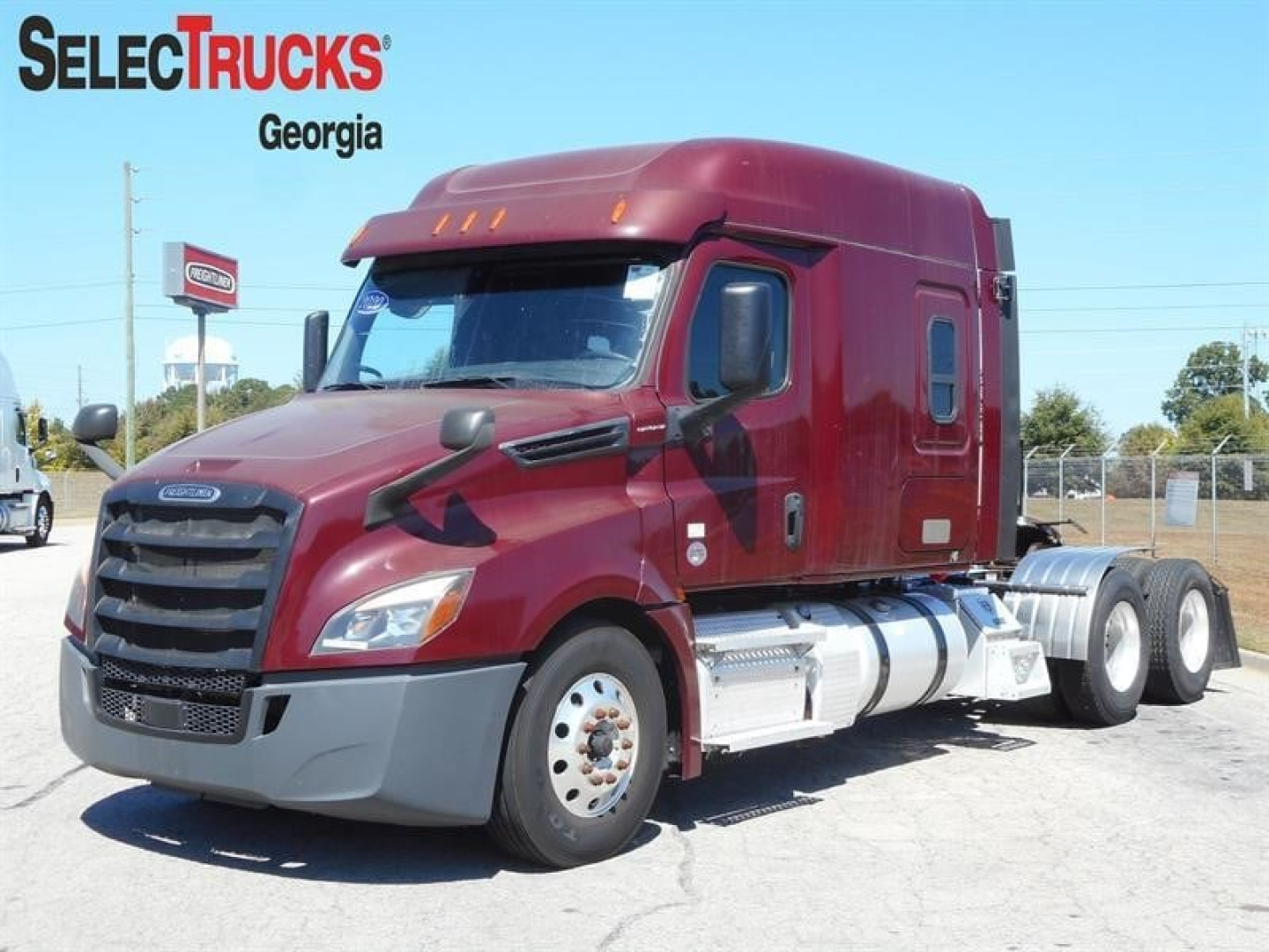 Freightliner Cascadia 126 tractor truck in maroon with sleeper cab, side view showing front grille and dual rear axle.