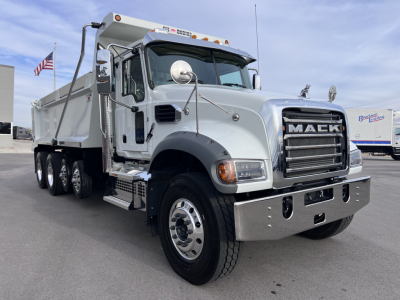 Mack GR64F dump truck showing chrome grille with MAEK lettering and large front bumper.