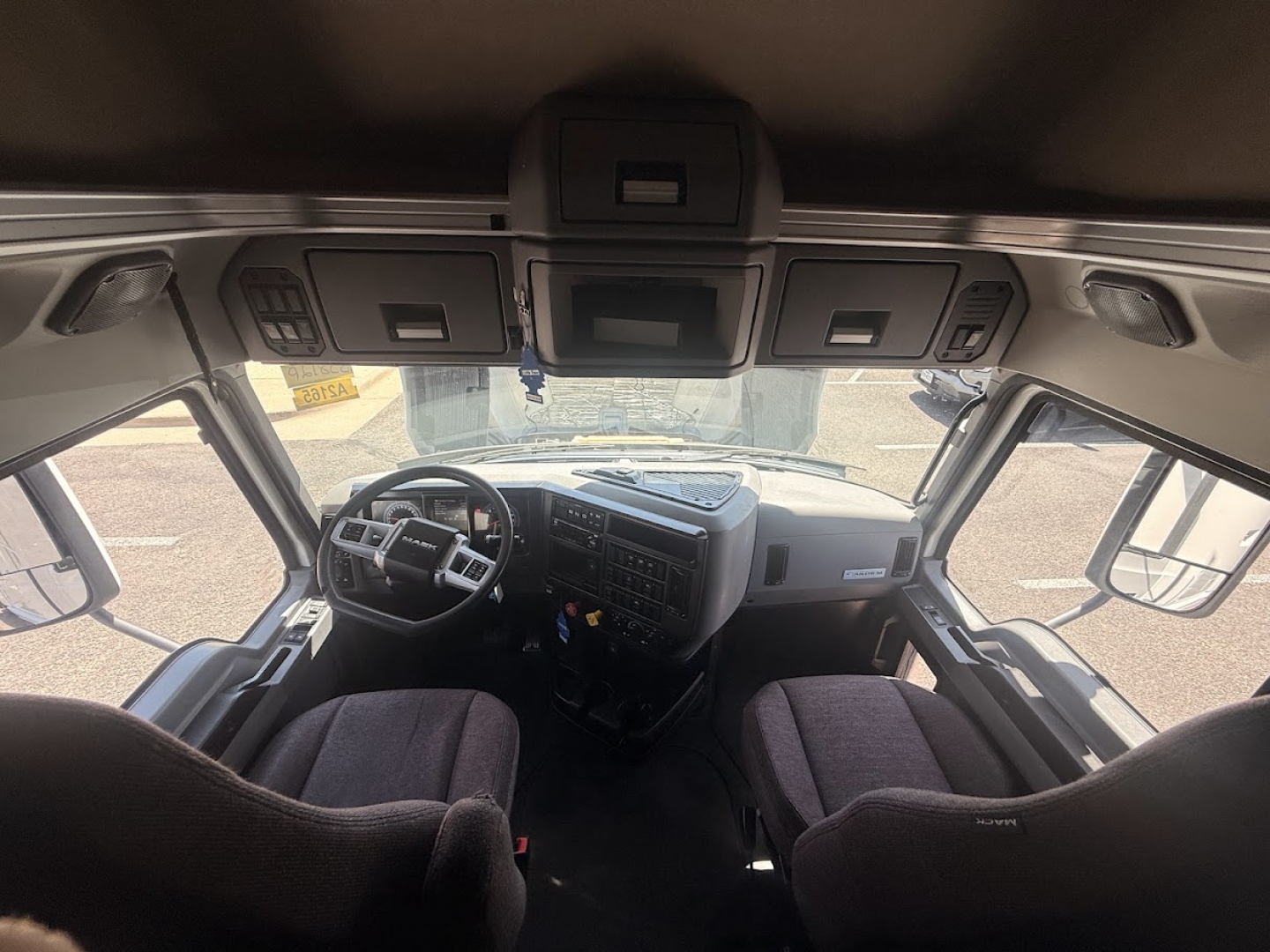 Cab interior of a 2020 Mack Anthem in-view showing dashboard, steering wheel, and front seats; overhead console and large windows.