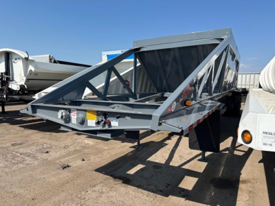 Ranco LW21-40 dump trailer in a yard showing open-weave truss frame with gray paint and reflective tape on sides.