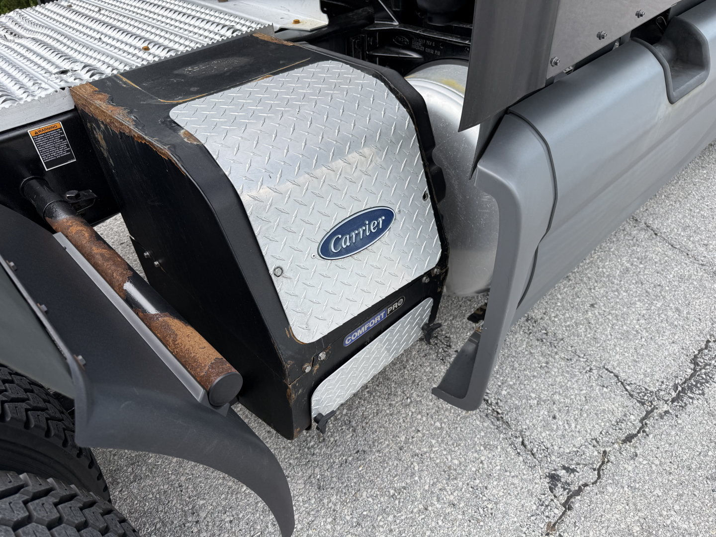 Carrier auxiliary power unit cover and surrounding truck components visible on a 2022 Peterbilt 579 engine bay area.