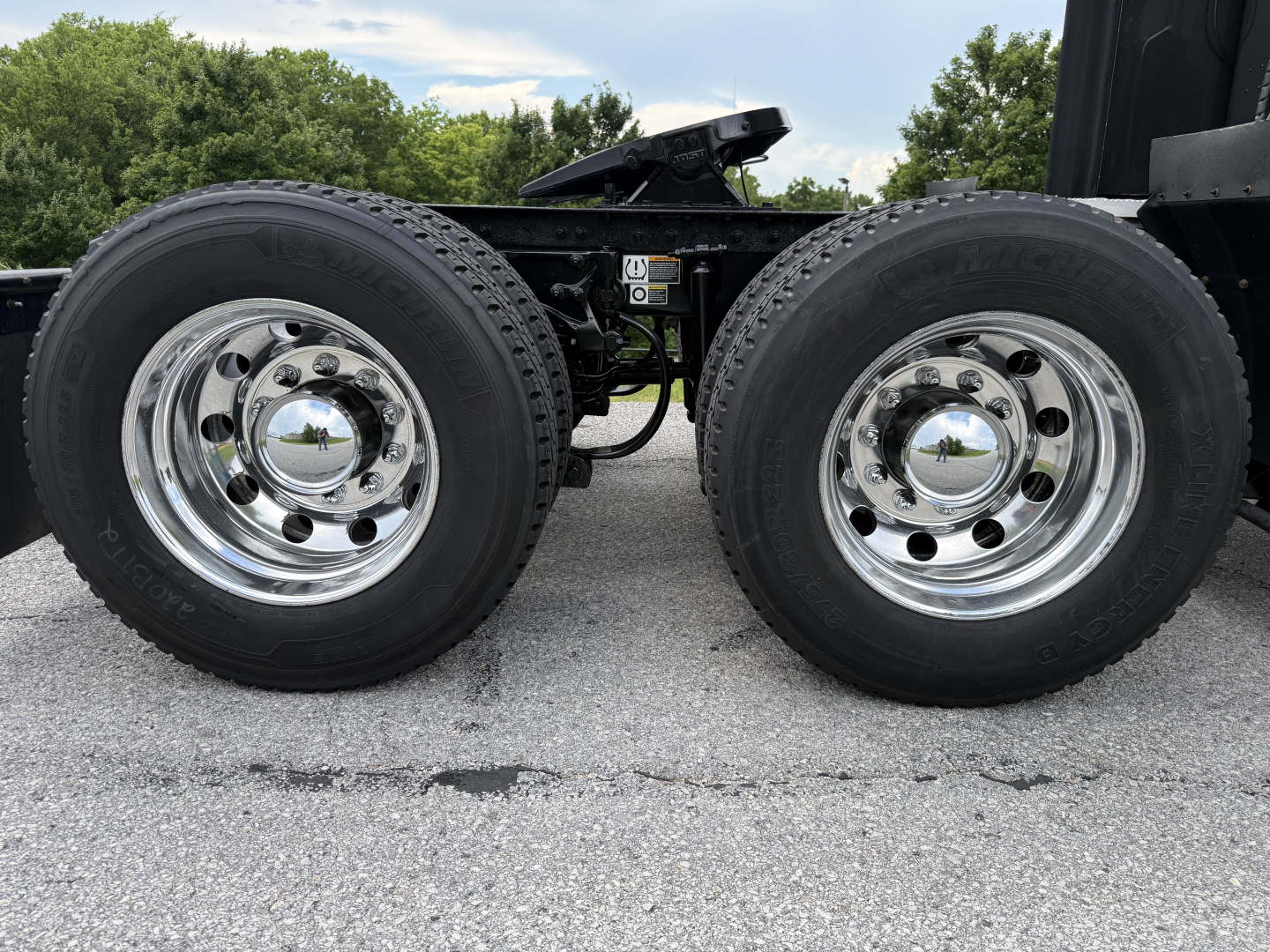 Peterbilt 579 truck chassis dual rear wheels showing chrome hubcaps and tires, near VIN and stock tag area.