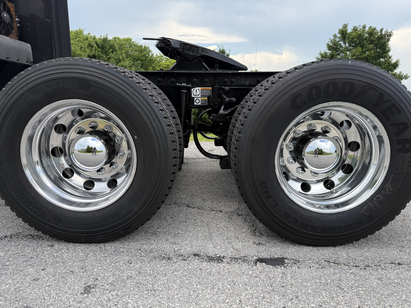 Peterbilt 579 truck dual rear wheels showing Goodyear tires and polished chrome rims, frame components visible.