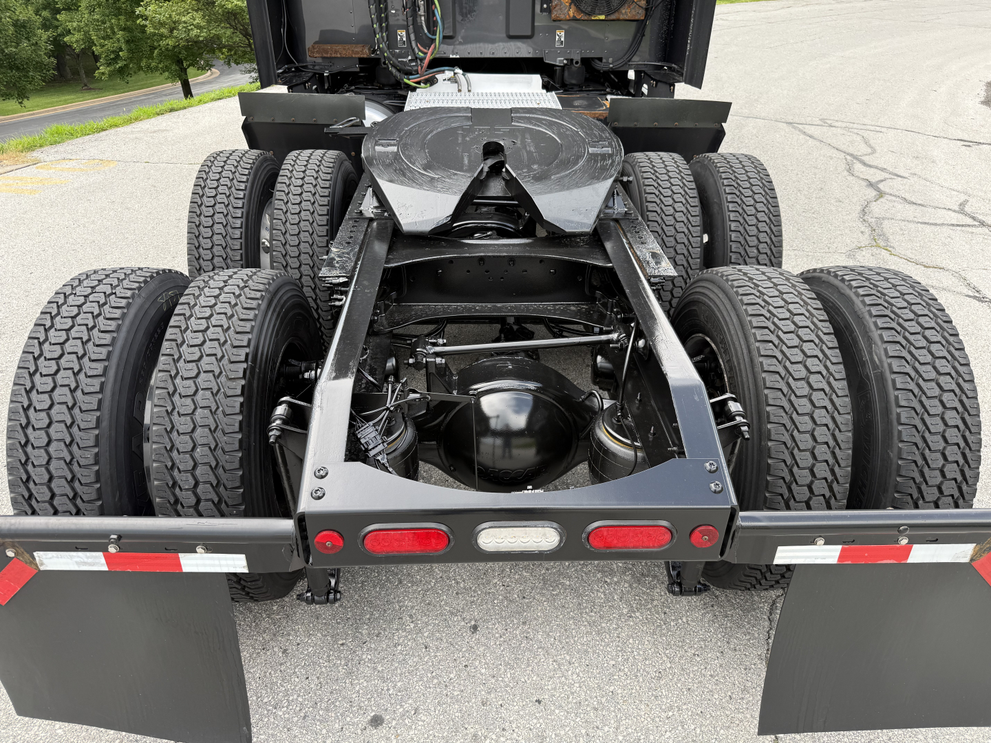 Truck rear view showing quintuple rear axle setup on a Peterbilt 579 chassis with fifth wheel and dual rear tires.