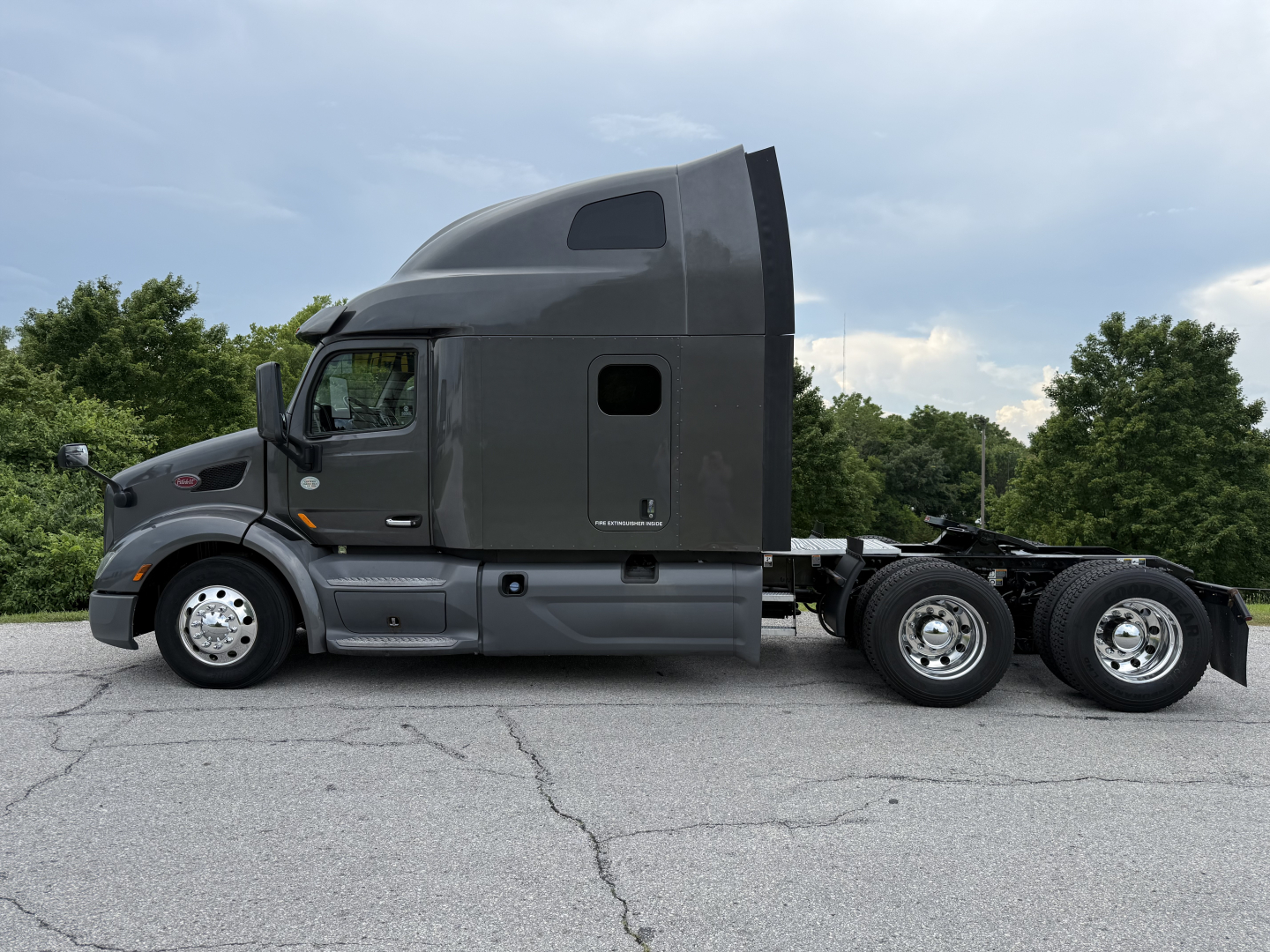 Peterbilt 579 truck side view with sleeper cab in gray, 6x4 chassis, dual rear axles, no visible damage.
