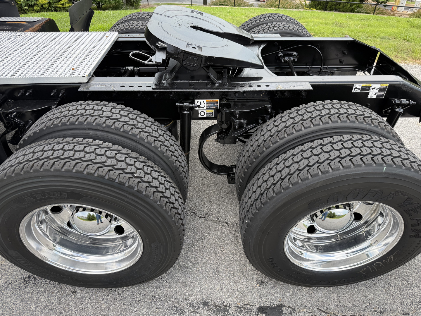 Peterbilt truck chassis showing dual rear axles and chrome wheels with tires, side view of fifth wheel area and frame.