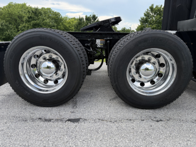 Peterbilt 579 truck chassis dual rear wheels showing chrome hubcaps and tires, near VIN and stock tag area.