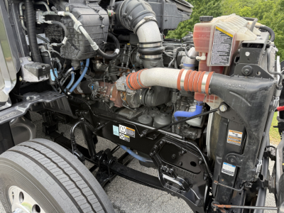 Peterbilt 579 engine bay showing intake hoses, coolant reservoir, and engine components visible in front of the cab.