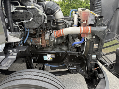 Peterbilt 579 engine bay close-up showing intake hoses, coolant reservoir, and engine components.