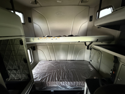 Peterbilt 579 cab interior with bunk bed and storage compartments; visible labels along bunk rail and window areas.