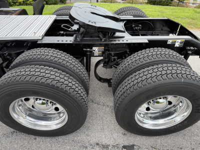 Peterbilt truck chassis showing dual rear axles and chrome wheels with tires, side view of fifth wheel area and frame.
