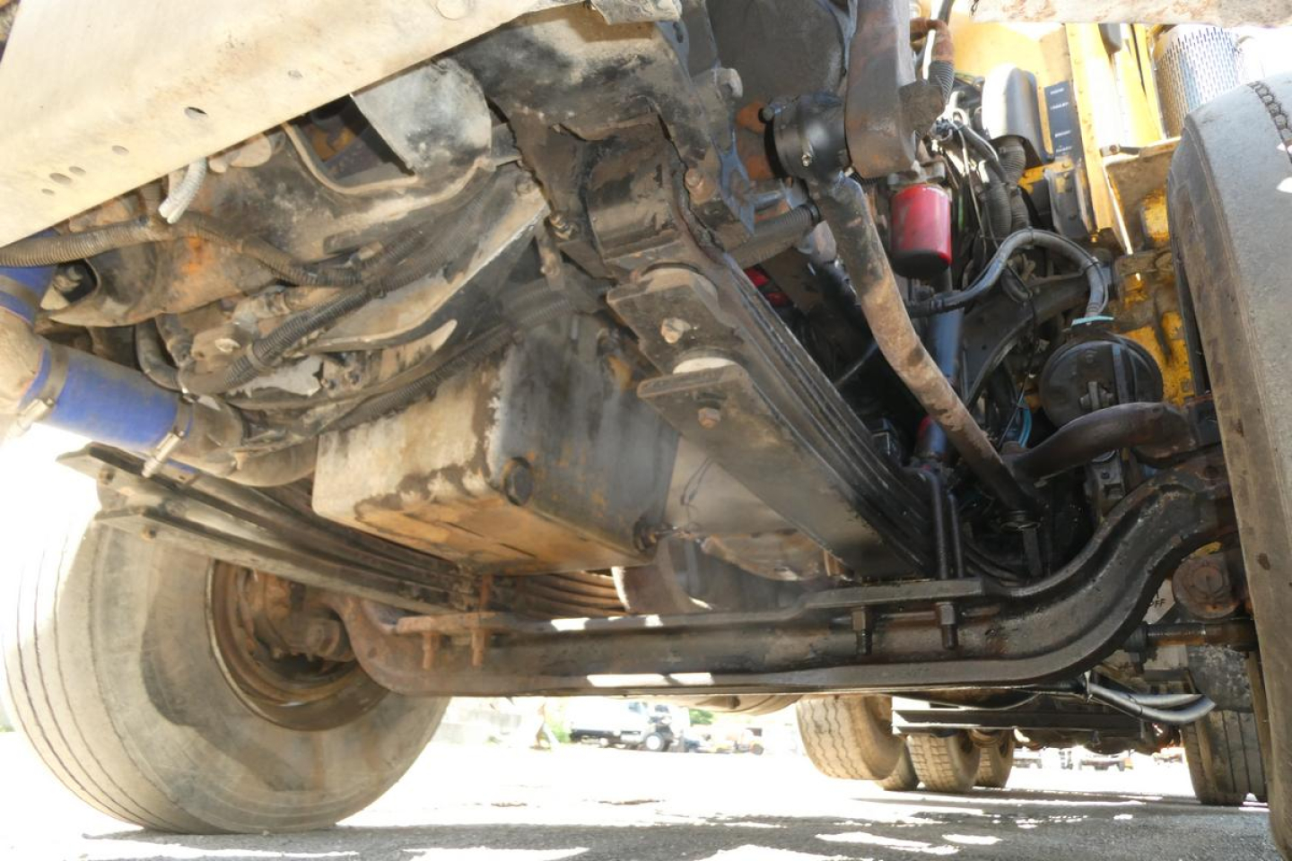 Underneath view of a 2005 Peterbilt 357 dump truck showing suspension, driveshafts, and frame components.