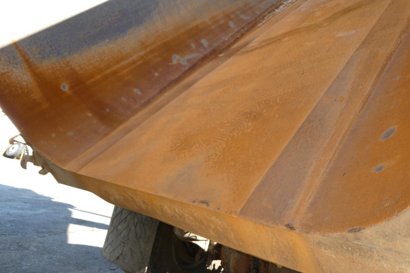 Dump truck bed showing rusted steel surface and edge of tailgate from a 2005 Peterbilt 357.