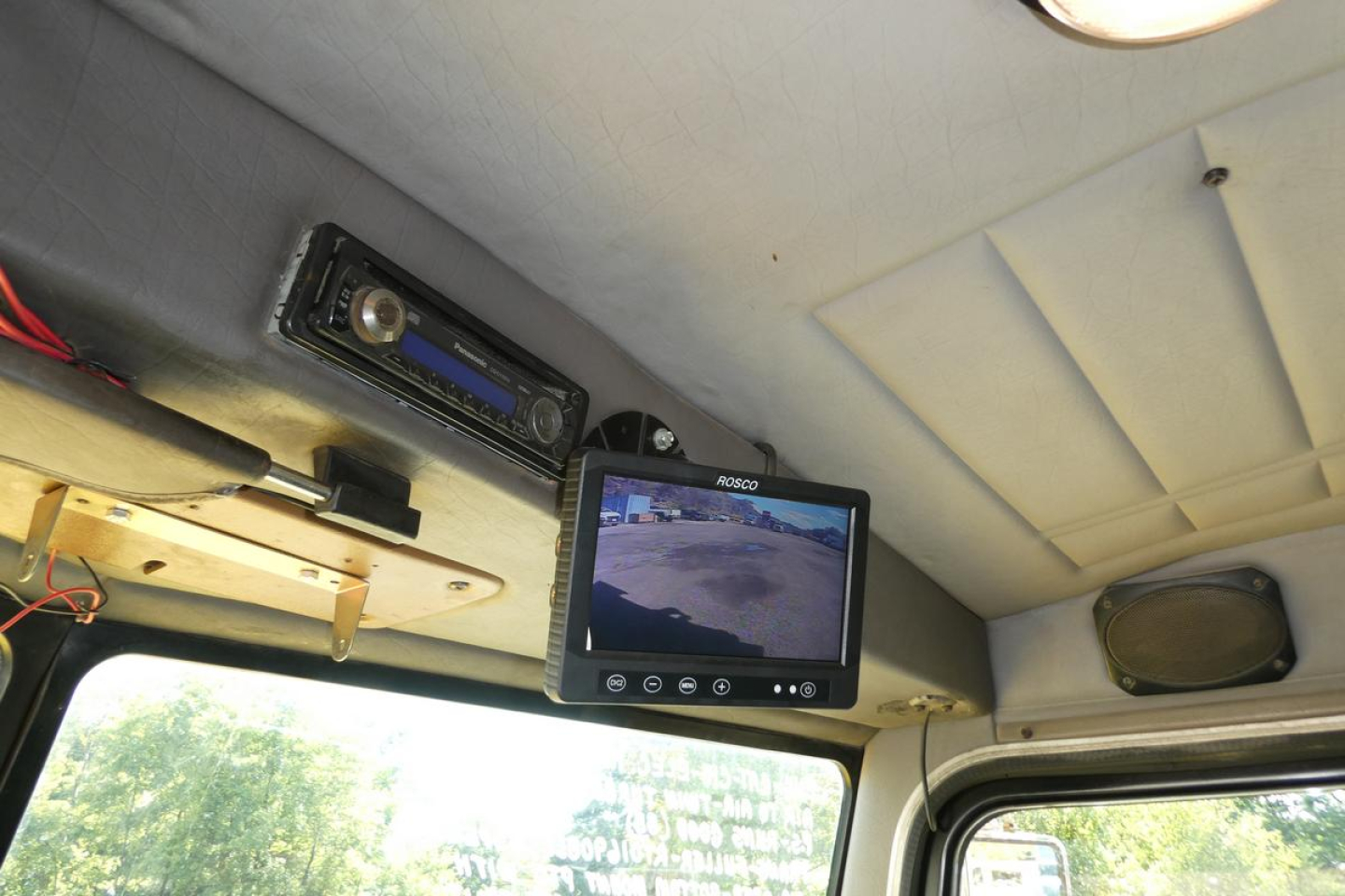 Dashboard area showing a flip-down monitor and a stereo unit in a Peterbilt cab. Visible text on screen: ‘KDSQ’ (on monitor).