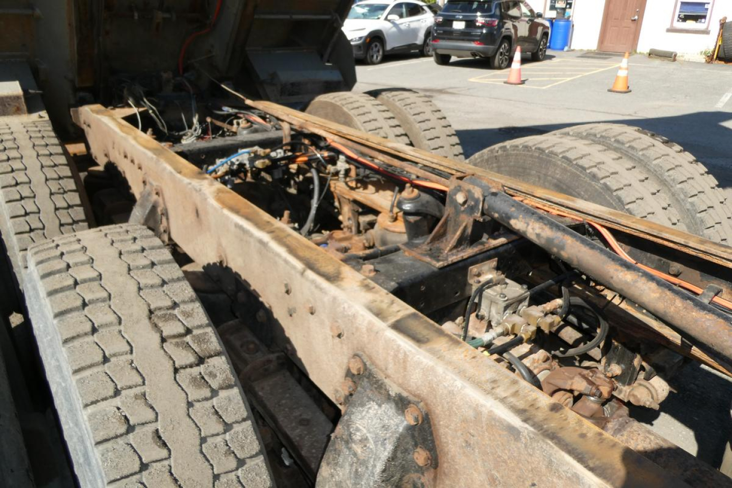 Peterbilt truck chassis undercarriage showing frame rails, dual rear axles, and drivetrain components in view.