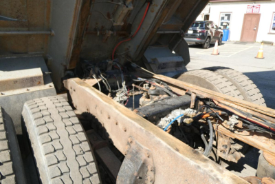 Dump truck chassis and engine bay showing exposed frame rails and wheel arches from a 2005 Peterbilt 357.