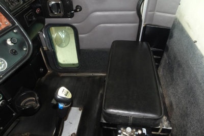 Interior cab area of a 2005 Peterbilt 357 dump truck showing bench seat, gear selector, door panel, and window. Visible text includes 'Peterbilt' on dash label and various switches.
