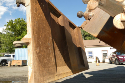Peterbilt dump truck bed portion with rust-colored metal and hydraulic linkage visible
