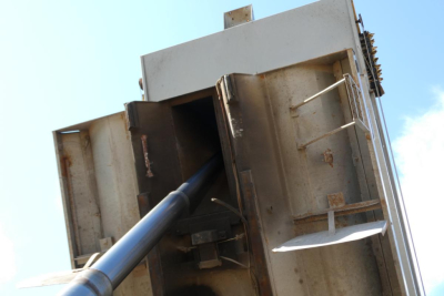 Dump truck bed with hydraulic lift and hydraulic cylinder visible, steel hopper sides, metal reinforcements and hinge mechanisms.
