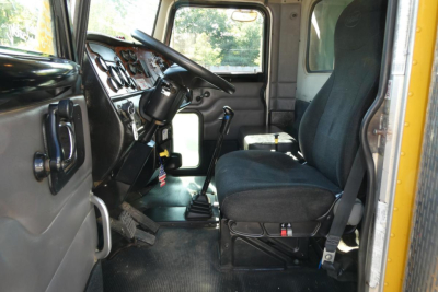 Peterbilt 357 dump truck cab interior with steering wheel, dashboard, and single black seat visible.