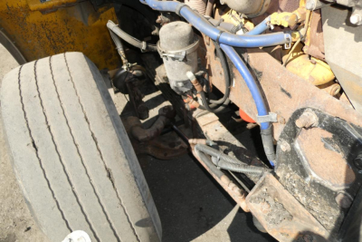 Peterbilt 357 engine bay showing blue hoses and exposed components near front wheel.