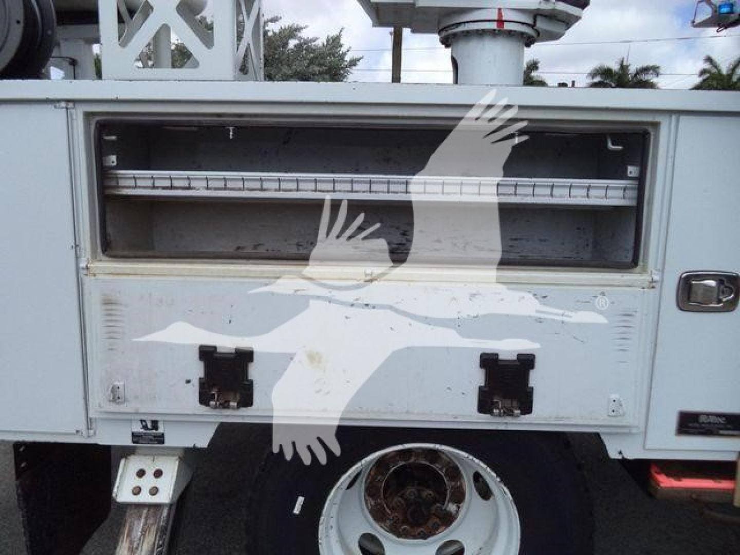 Front of a 2021 Altec L37M crane body showing storage compartments and wheel. Visible text includes nothing legible beyond general equipment components.
