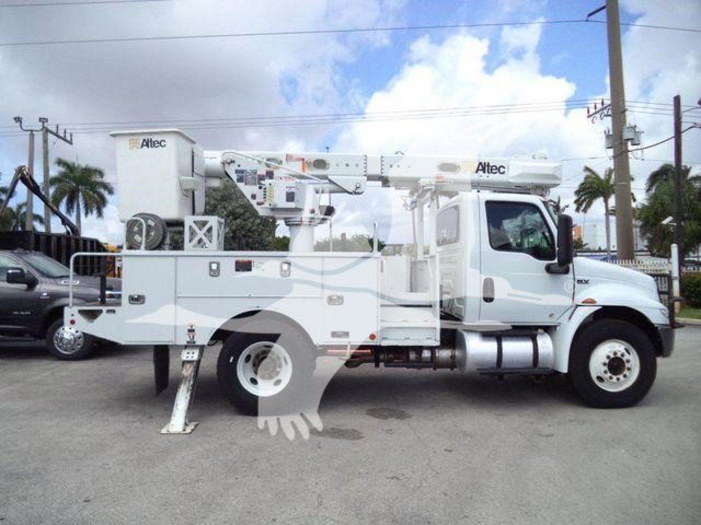 Altec L37M crane truck in side view, white bucket crane equipment, stabilizers down, mounted on a medium-duty truck chassis, with control panels and outriggers visible.