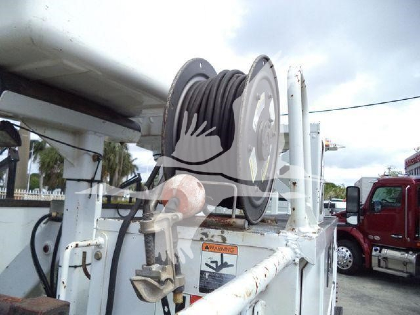 Altec L37M crane service winch reel and control housing with cable drum and warning label visible.