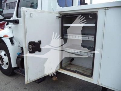 Altec L37M crane equipment bay door open showing empty storage compartment and shelves.