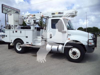 Altec L37M boom truck crane on white cab and chassis with utility compartments, crane boom retracted overhead, TLC dealer lot.