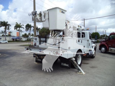 Altec L37M boom truck with elevated platform mounted on a white service truck. Visible text includes 'Altec' on bucket crane and on mud flaps. Rear view shows stabilizer legs deployed and a black license plate area; equipment category crane
