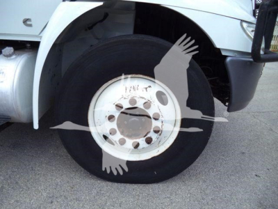 Altec L37M crane front wheel view showing white steel wheel, black tire, and part of the truck fender.