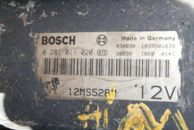 Label on vehicle showing BOSCH branding, 'Made in Germany', barcode, and serial numbers; '12MS52B' and '12V' visible; dog icon; various numbers including 0 281 011 020, 030830, 1039S1639, 38830, 185E 0141.