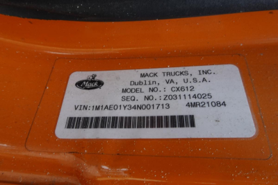 Mack Trucks label on orange cab showing model CX612, VIN 1M1AE01Y34N001713, stock number 1015252, sequence Z031114025