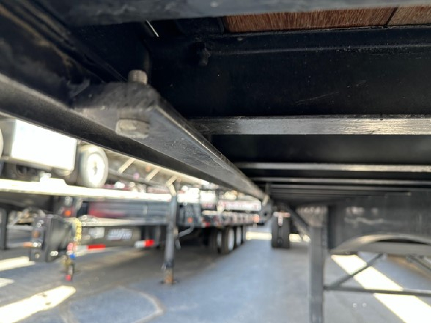 Flatbed trailer underside view showing frame and bolster rail of a 2027 Utility 4000S trailer.