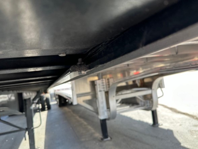 Flatbed trailer underside and support legs showing structural beams and mounting hardware.