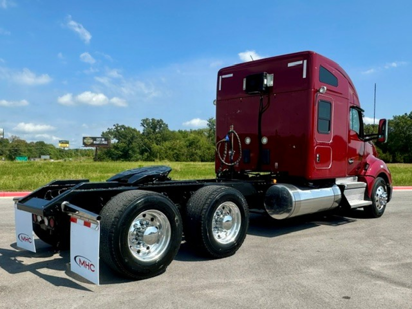 Kenworth T680 2022 side-profile view showing sleeper cab and dual rear axles, red exterior, chrome fuel tanks, and tires.