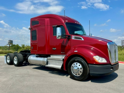 Kenworth T680 conventional sleeper truck in red, side view showing front fender, chrome fuel tank, wheels, and dual rear axles.