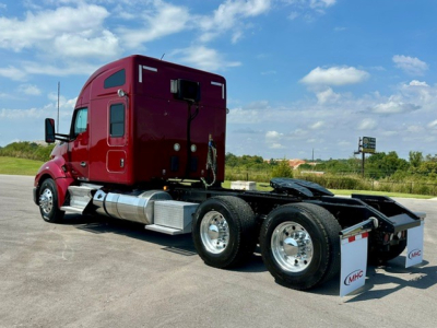 Kenworth T680 tractor unit side view showing dual rear axles and fuel tanks.