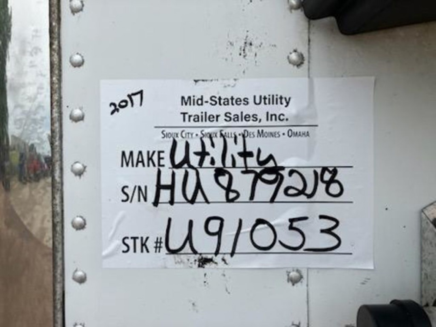 Sticker on trailer door showing 2017 Mid-States Utility Trailer Sales Inc., S/N HU879218, STK# U91053, Make: Utility Trailer, 2017 written, used condition.