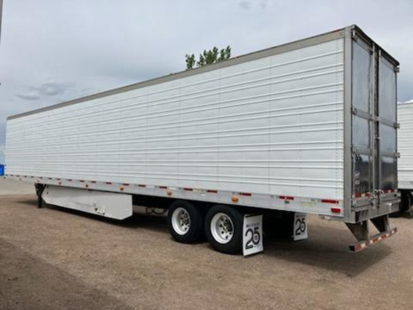 Trailer side view showing a 2017 Utility reefer trailer with a white aluminum side, dual rear axles, and a hinged rear door.