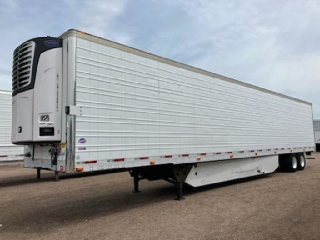 Utility refrigerated trailer with a curved front, white exterior, thermoking cooling unit on nose, trailer legs down, dual rear axles, side rails, shipping reflectors.