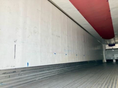 Trailer interior showing aluminum side wall and ribbed floor of a refrigerated trailer.