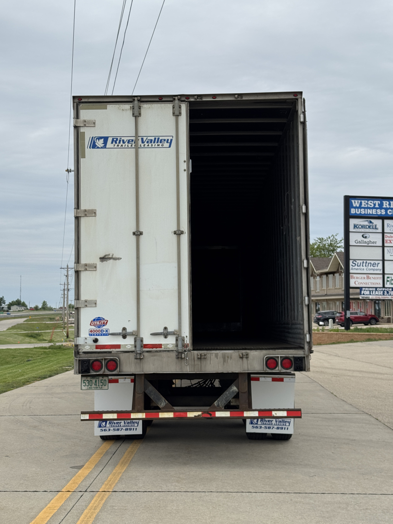Rear view of a 2014 Utility 4000D-X trailer with open rear doors. River Valley branding on left door, taillights, bumper reflectors, and various stickers visible.