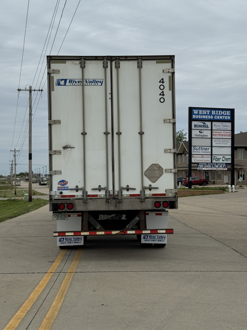 Rear view of a utility trailer truck with number 4040 on doors, River Valley logo, and taillights.