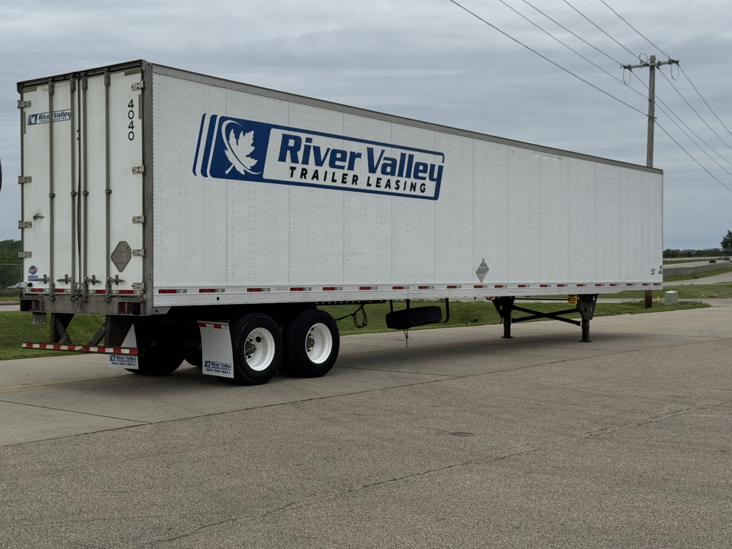 Trailer side view showing River Valley Trailer Leasing logo on a Utility 4000D-X trailer.